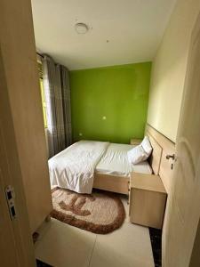 een groene slaapkamer met een bed in een kamer bij Private house in Kibagabaga in Kigali