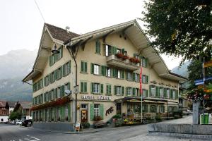 a large building with green shutters on a street at Baeren Hotel, The Bear Inn in Wilderswil