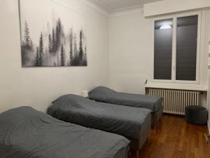 Habitación con 2 camas y una foto en la pared. en Paris Apartment 5-minute walk to tube station, en Les Lilas