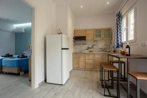 a kitchen with a white refrigerator and a table at Paradiso Aparthotel in Ýpsos