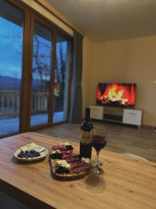 a table with a plate of food and a glass of wine at Villas Bašović in Šavnik
