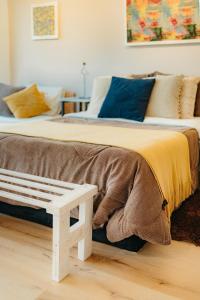 two beds with pillows and a bench in a room at Increíble Habitación con piscina y hermosa vista. in La Mesa