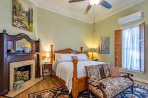 a bedroom with a bed and a chair and a fireplace at The Gallery House Boutique Hotel in Stephenville