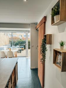 a kitchen with white walls and wooden cabinets and a table at BEACH HOUSE 100M PLAGE, SUR LE PORT. in Frontignan