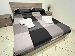 ポンテ・ガレリアにあるCasa Vacanza Fiera di Romaの大型ベッド(白黒のシーツ、タオル付)
