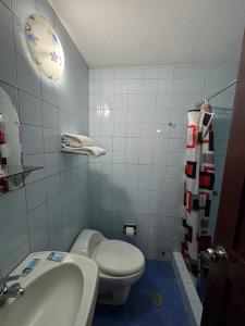 een badkamer met een wit toilet en een wastafel bij Hotel Los Angeles in Arequipa