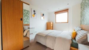 um quarto com uma cama e uma janela em Leeds City Centre Dock 2 Bed 2 Bath em Hunslet