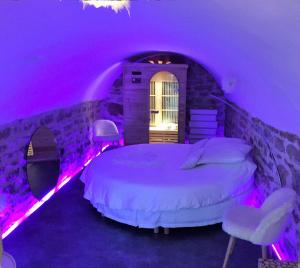 Cette chambre violette comprend un lit et deux chaises. dans l'établissement Ly'Ove, à Lyon