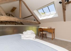 a bedroom with a bed and a desk and a window at The Hay Loft in Swafield