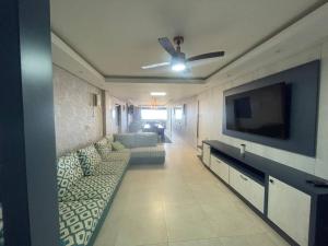 a living room with a couch and a flat screen tv at Apartamento Vista para o Mar in Laguna