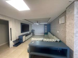 a room with a couch and a tv in a room at Apartamento Vista para o Mar in Laguna +5 photos