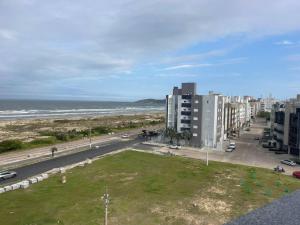 a view of a street and the ocean with buildings at Apartamento Vista para o Mar in Laguna