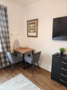 a room with a table and two chairs and a television at Immaculate 1-Bedroom in Greenhithe in Greenhithe