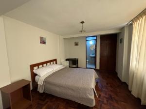 een slaapkamer met een groot bed en een raam bij Hotel Los Angeles in Arequipa