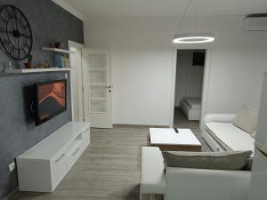 a living room with a couch and a tv at Apartment Maska in Budva