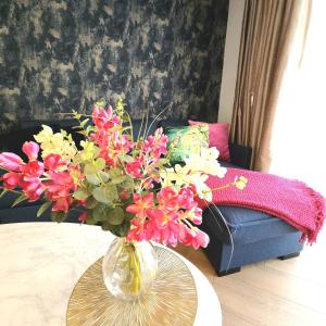 a vase with flowers on a table in a living room at Trinity- New Modern Apartment with FREE on road parking in Girton