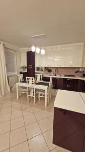 eine Küche mit weißen Schränken sowie einem Tisch und Stühlen in der Unterkunft Appartamento Oro in Mantello