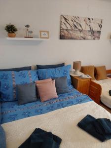 uma sala de estar com um sofá azul e uma cama em Léna apartman em Fonyód