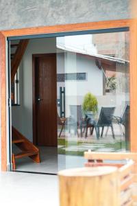 een open glazen deur van een huis met een patio bij Portal das Guaratibas in Prado