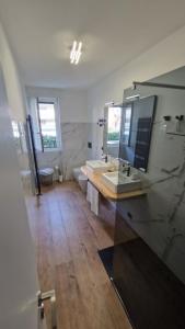 ein Badezimmer mit einem großen Spiegel und einem Waschbecken in der Unterkunft Appartamento Oro in Mantello
