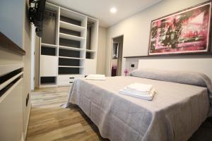 a room with two beds with towels on a table at Corte Nerina Malpensa in Somma Lombardo