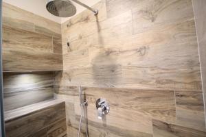 a bathroom with a shower with wooden walls at Corte Nerina Malpensa in Somma Lombardo +14 photos