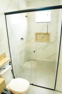 een glazen douche in een badkamer met een toilet bij Portal das Guaratibas in Prado