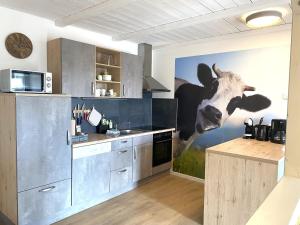 una cocina con una pintura de una vaca en la pared en Wiesen-Hof, 