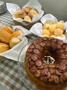 uma mesa coberta com uma tarte e vários produtos de pastelaria em Hotel Rio Jordão em Siderópolis
