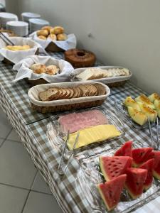 einen Tisch mit verschiedenen Brotsorten und Früchten in der Unterkunft Hotel Rio Jordão in Siderópolis