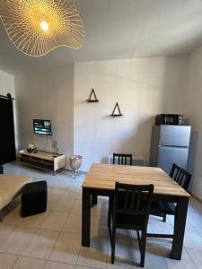 a living room with a table and chairs and a kitchen at Le Foch_Beziers Centre_wifi in Béziers