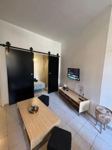 a living room with a table and a tv at Le Foch_Beziers Centre_wifi in Béziers
