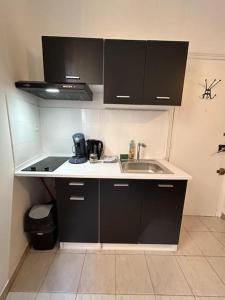 a small kitchen with a sink and a stove at Le Foch_Beziers Centre_wifi in Béziers