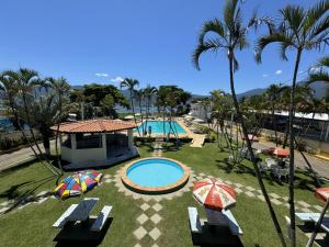 un complejo con 2 piscinas y sombrillas en Hotel Recanto dos Pássaros, en São Sebastião