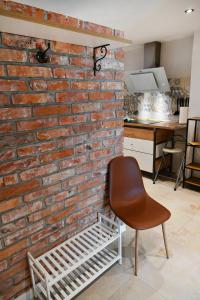 eine Backsteinwand mit einem Stuhl neben einer Küche in der Unterkunft APARTMAN Tradicia in Michalovce