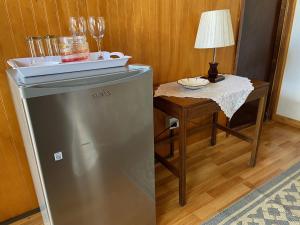 a kitchen with a refrigerator and a table with a lamp at Hotel Cabañas Caribe in Los Vilos
