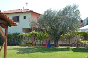 a yard with a tree and a playground at Nikos & Panagiota in Vourvourou