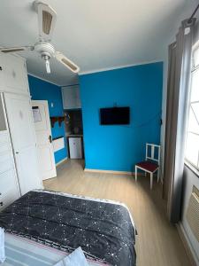 um quarto azul com uma cama e uma parede azul em Suíte Hotel São José em Caxambu