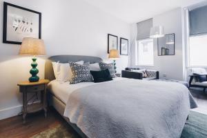 a bedroom with a bed and a table with a lamp at South Street Apartments in Chichester