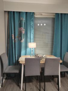 une table à manger avec des chaises et un rideau bleu dans l'établissement City Apartment, à Tampere