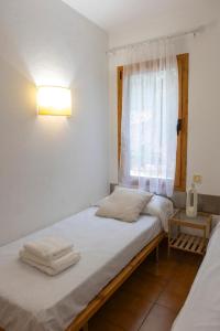 a small bedroom with a bed with a window at Fee4Me Menorca, appartment a few minutes from the beach in Arenal d'en Castell