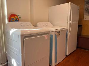 a washer and dryer in a kitchen with a refrigerator at Chic 2BR Suite in Vancouver West~UBC & Downtown in Vancouver
