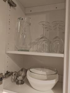 uma cozinha com frascos de vidro e uma tigela numa prateleira em City Apartment em Tampere
