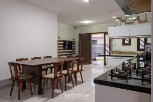 - une cuisine et une salle à manger avec une table et des chaises dans l'établissement Casa 3 quartos a 50m da praia Penha-SC EPS055, à Penha