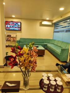 新德里的住宿－RoseMallow Tavisha Hotel，客厅,桌子上放着花瓶