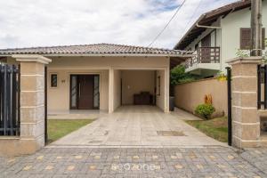 une maison avec une allée menant à un garage dans l'établissement Casa 3 quartos a 50m da praia Penha-SC EPS055, à Penha