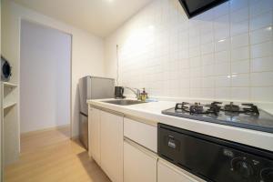 a kitchen with a stove and a sink and a refrigerator at Liberte Nakajima Park Room 201,302 - Vacation STAY 98202v in Sapporo