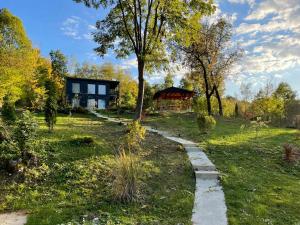 ein Haus inmitten eines Feldes mit einem Pfad in der Unterkunft Casa de pe un Deal-Provita de Sus-Prahova in Proviţa de Sus