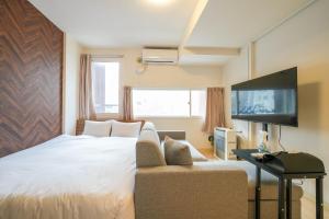 札幌市にあるLiberte Nakajima Park Room 201,302 - Vacation STAY 98216vのベッドルーム(ベッド1台、ソファ、テレビ付)