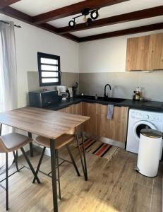 - une cuisine avec une table en bois et un évier dans l'établissement Le Cosy Appartement, à Saint-Pierre